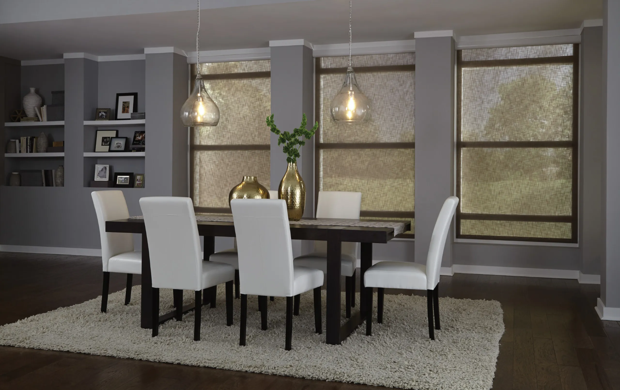 Modern dining room with closed taupe woven shades glowing with daylight, white chairs, and glass pendants