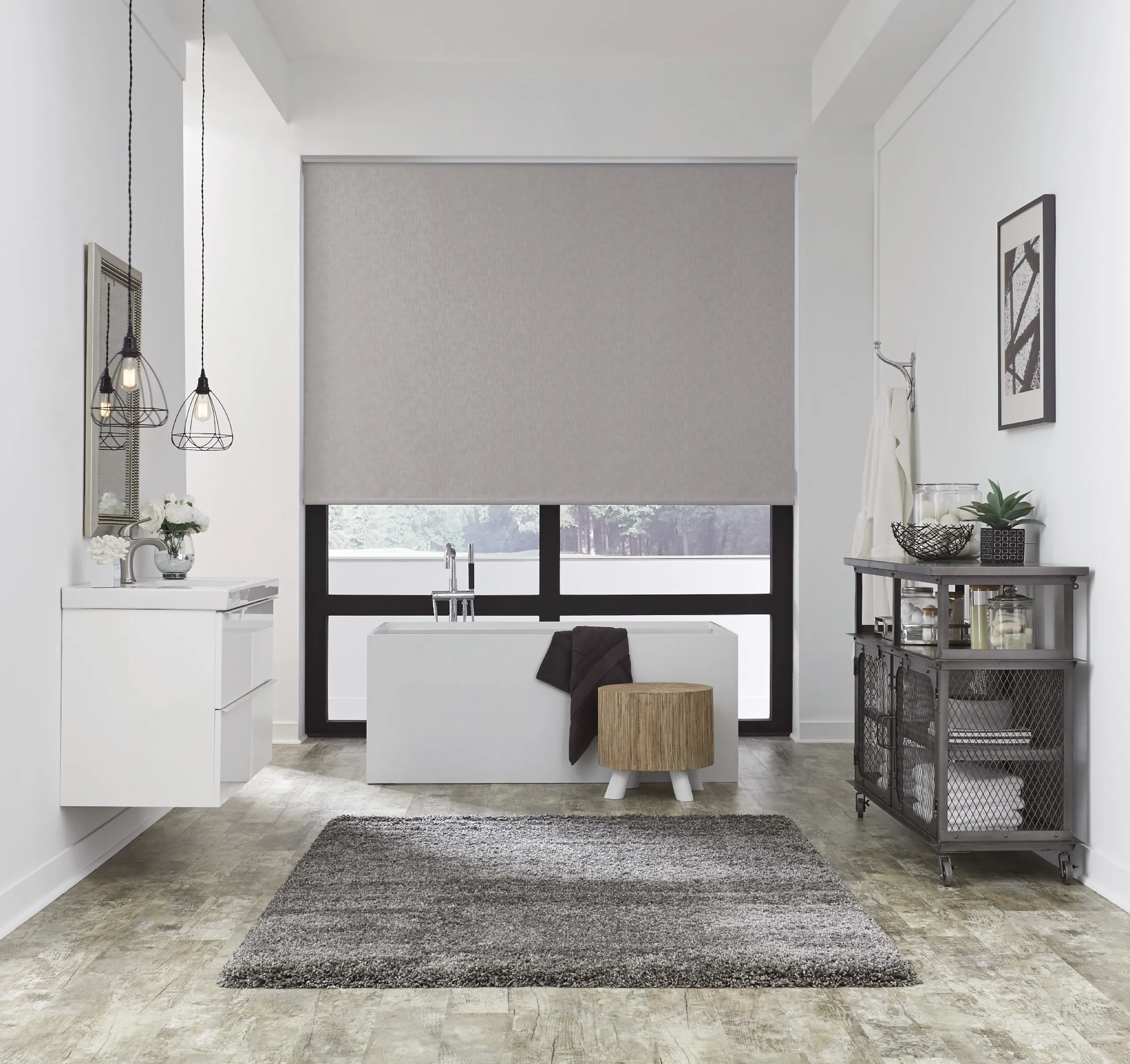 Modern bathroom with freestanding tub and a large gray roller shade covering floor-to-ceiling windows.