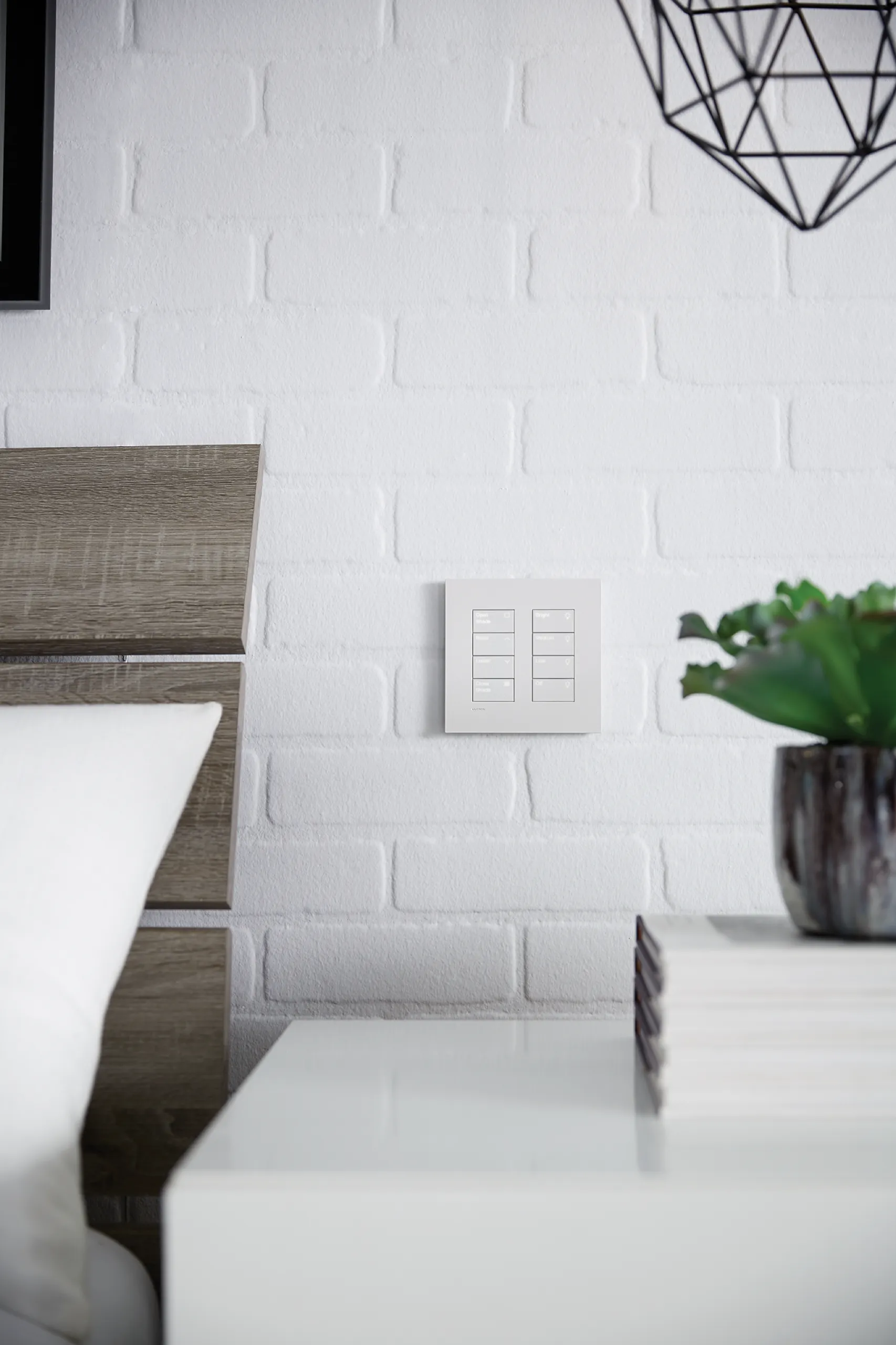 Dual white four-button wall keypads on painted brick beside a wood headboard and white nightstand.