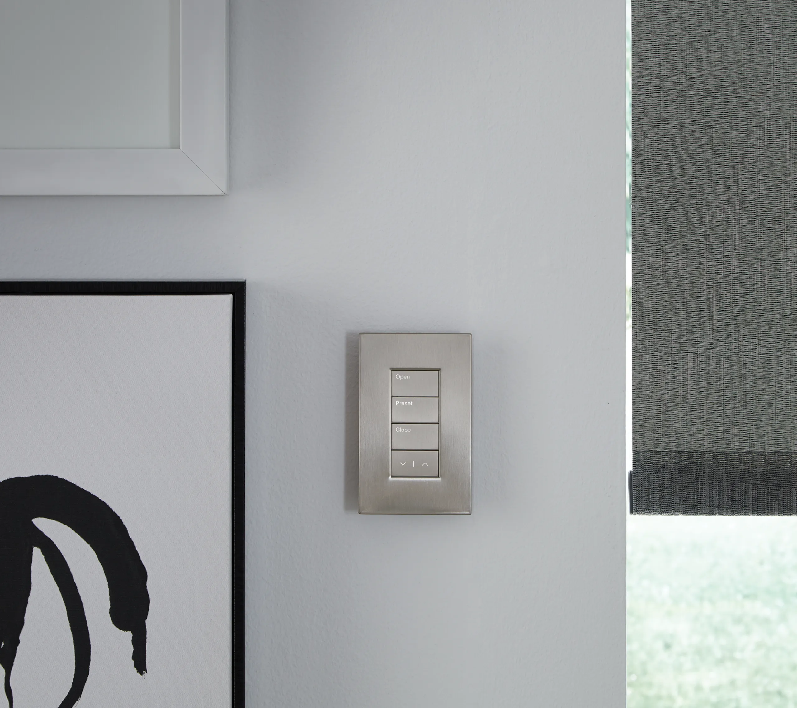 Satin nickel four-button shade keypad labeled Open, Preset, and Close on a light gray wall