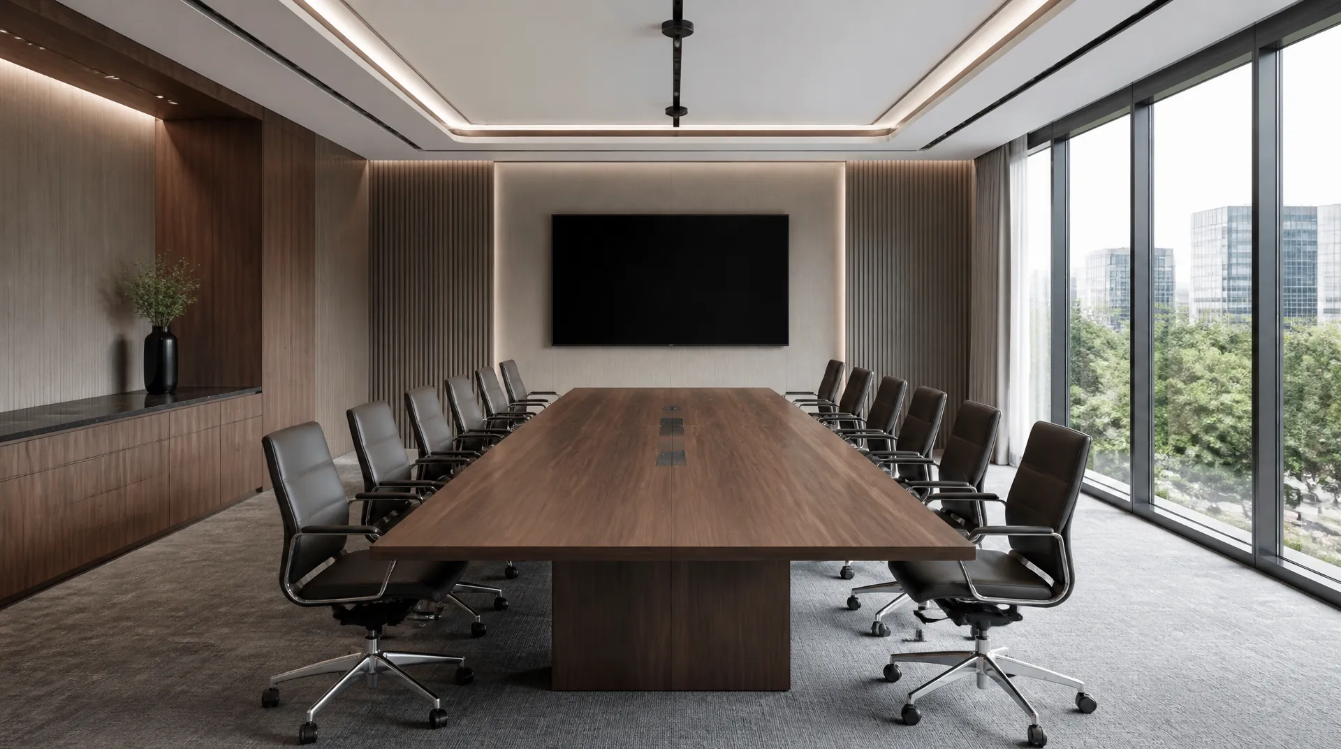 Boardroom with a long walnut table and twelve leather chairs, a wall display switched off, and a slim microphone array suspended above the table.